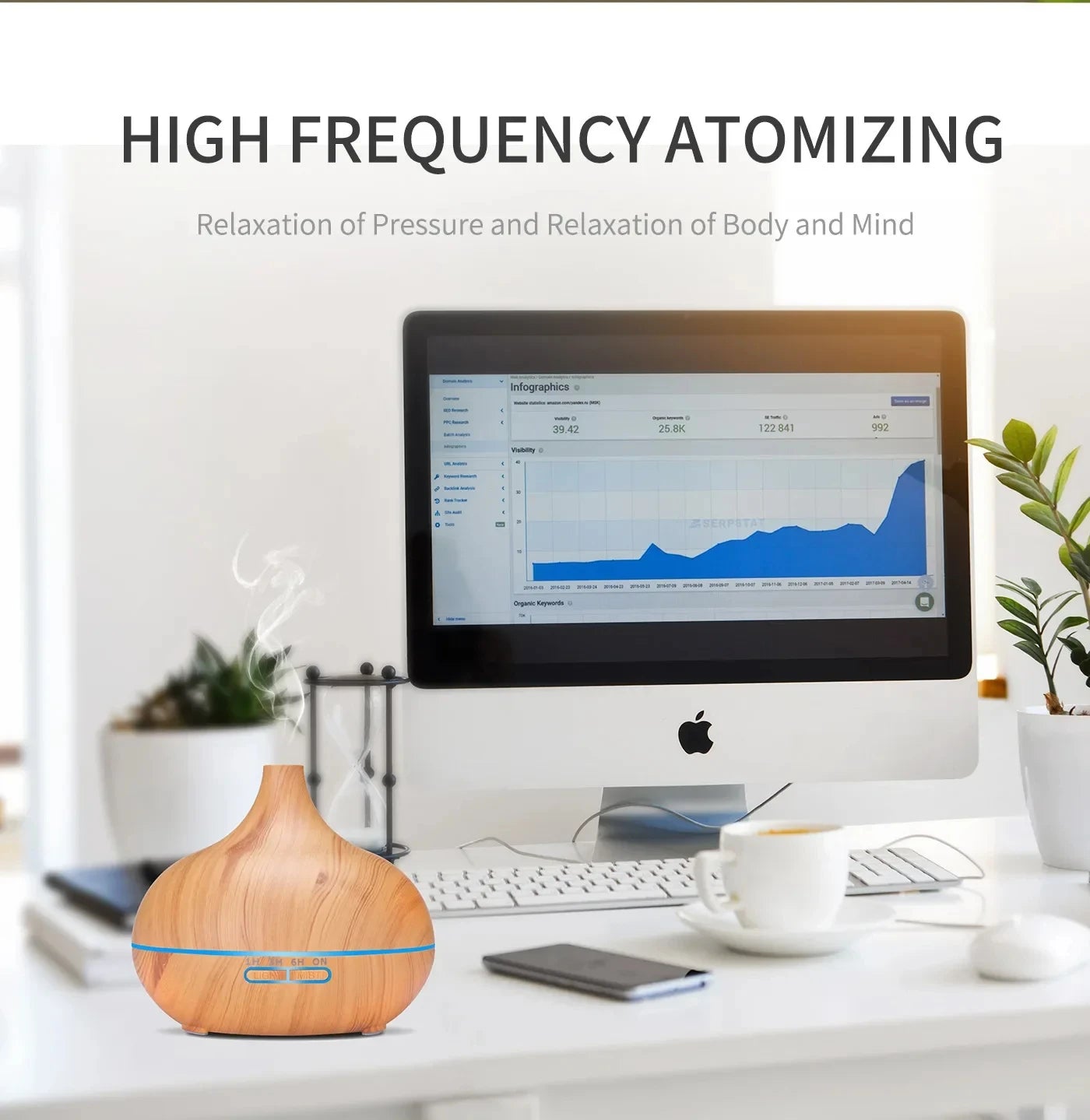 Wood grain essential oil diffuser emitting mist on a desk with a computer, promoting relaxation and stress relief.